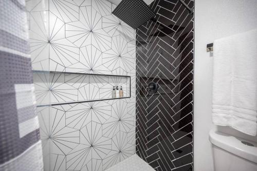 a bathroom with a black and white tiled wall at Luxury Retreat The Vegas Edition in Las Vegas