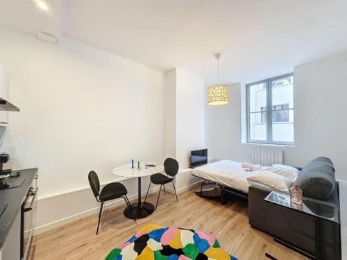 un salon avec un lit, une table et des chaises dans l'établissement Cosy studio, Centre Ville Thomassin 2, à Lyon