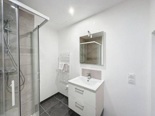 y baño blanco con lavabo y ducha. en Cosy studio, Centre Ville Thomassin 2, en Lyon