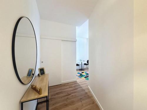Habitación con espejo en la pared y mesa. en Cosy studio, Centre Ville Thomassin 2, en Lyon