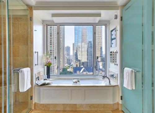 a bathroom with a bath tub and a window at The Peninsula Chicago in Chicago