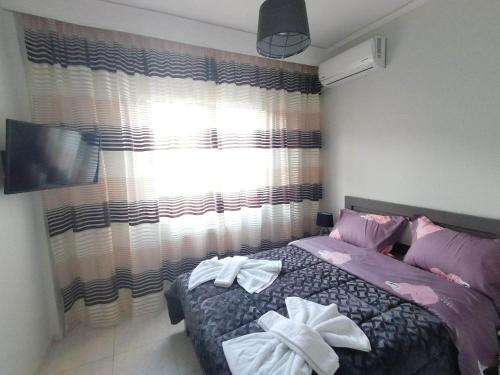 a bedroom with a bed with two white bows at DZ Apartment AXD in Alexandroupoli