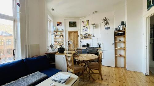 a living room with a table and a kitchen at ApartmentInCopenhagen Apartment 1586 in Copenhagen