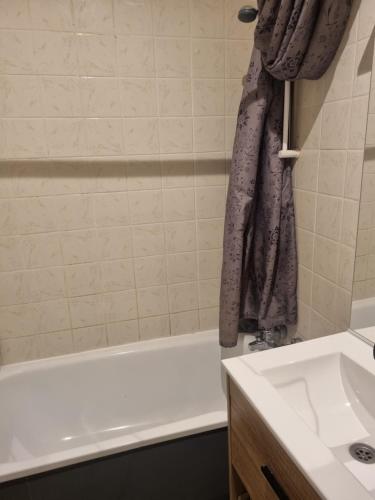 a bathroom with a white tub and a sink at Capitaine in Mulhouse