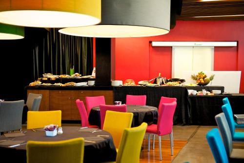 a dining room with a table and colorful chairs at Mercure Nerocubo Rovereto in Rovereto
