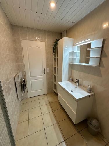 y baño con lavabo blanco y espejo. en Hédoniste, en Herpy-lʼArlésienne