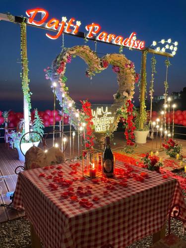 uma mesa com uma garrafa de vinho e dois corações em DAJTI PARADISE RESORT em Tirana