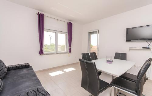 a living room with a table and chairs and a tv at Elegant Villa Jure with private pool in Poličnik