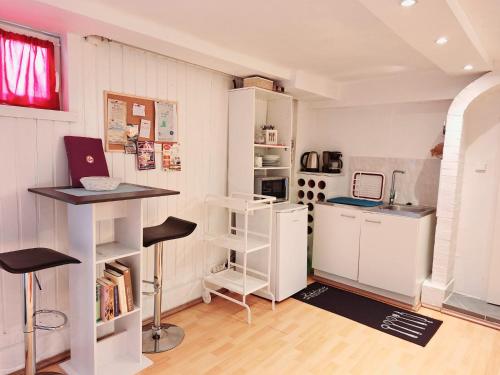 una pequeña cocina con armarios blancos y una encimera en Basement Room en Mönchengladbach