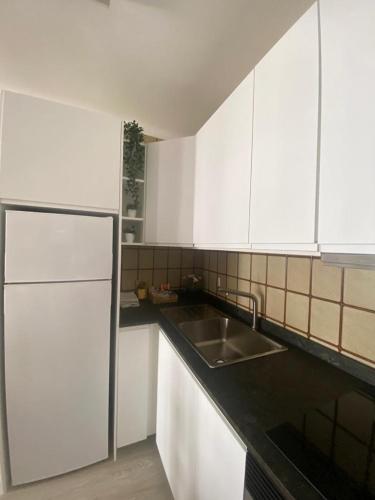 a kitchen with white cabinets and a sink at Rotonda Apartaments in Felanitx