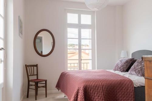 a bedroom with a bed and a mirror and a chair at Regina's Banyuls - Exklusiv lägenhet med havsvy in Banyuls-sur-Mer