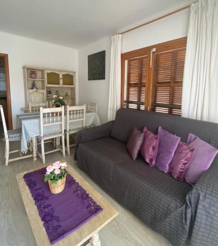 a living room with a gray couch and purple pillows at Rotonda Apartaments in Felanitx