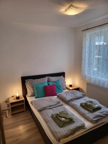 una camera da letto con un grande letto con due cuscini di TriAngol Apartman: fürdő, belváros, egyetem a Győr