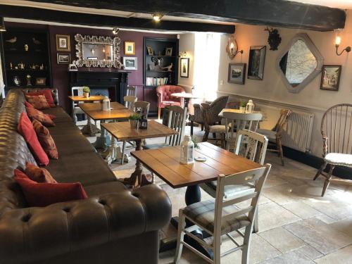 um restaurante com um sofá, mesas e cadeiras em The Tavern em Matlock