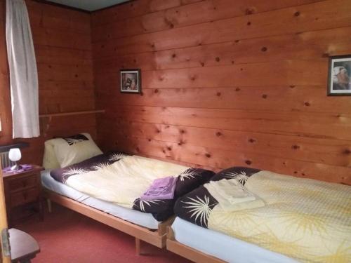 een slaapkamer met een bed in een houten muur bij Chalet Holzwurm in Oberried