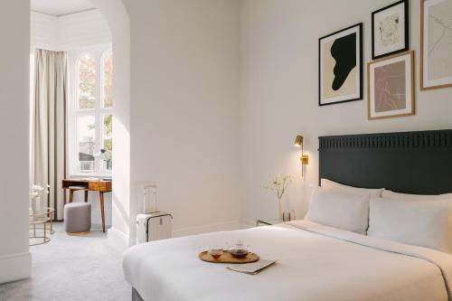 een slaapkamer met een bed met een dienblad met eten erop bij Sonder Kensington Gardens in Londen