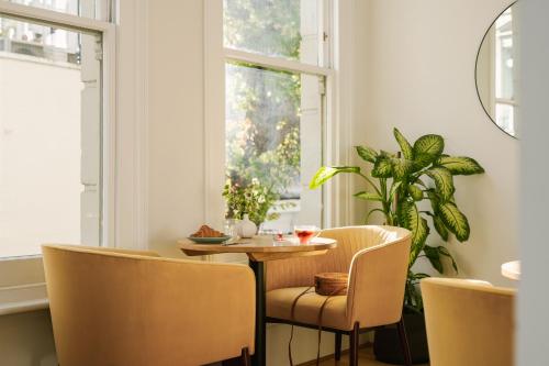 a dining room with a table and chairs and a window at Sonder Kensington Gardens in London