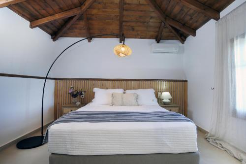 una camera con un grande letto e una lampada a pavimento di Georgia Villas a Drymon