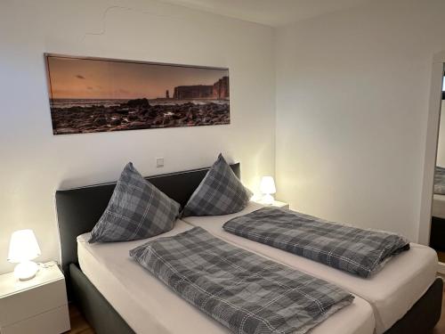 ein Schlafzimmer mit 2 Betten und einem Bild an der Wand in der Unterkunft Tor zum Meer in Helgoland