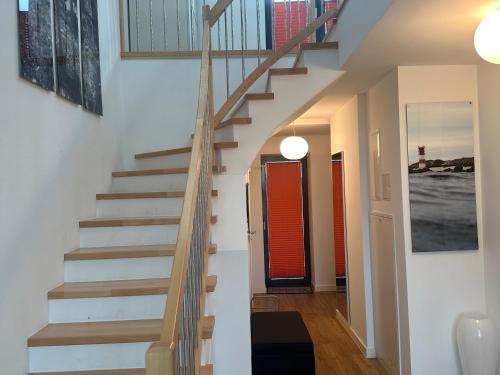 a staircase in a home with white walls and wooden floors at Tor zum Meer in Helgoland