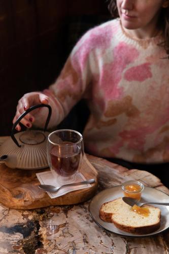 a woman is sitting at a table with a plate of bread at La Ferme du Golf in Megève