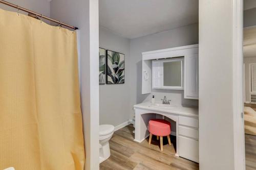 a bathroom with a white toilet and a sink and a red stool at Augusta 5bd: 10min to Golf Course - BBQ Grill in Augusta
