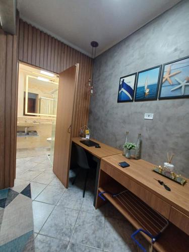 un bureau avec un bureau en bois et une salle de bain dans l'établissement Apartamento Aconchegante, à Praia Grande