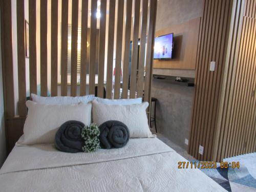 une chambre avec un lit avec deux serviettes dessus dans l'établissement Apartamento Aconchegante, à Praia Grande