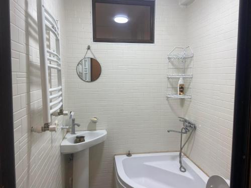 a white bathroom with a sink and a toilet at Шотико Квартира in Tbilisi City