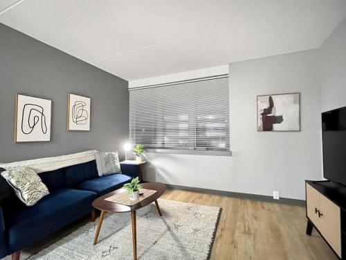 a living room with a blue couch and a window at Downtown 1br Gem Steps Away From Wells Fargo in Des Moines