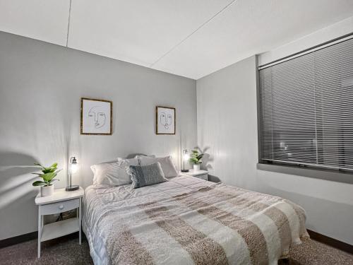 a bedroom with a large bed and a window at Downtown 1br Gem Steps Away From Wells Fargo in Des Moines