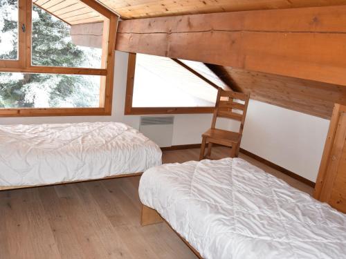 une chambre avec deux lits et une chaise dedans dans l'établissement Duplex chaleureux avec garage, proche centre, domaine La Plagne-Paradiski - FR-1-464-41, à Champagny-en-Vanoise