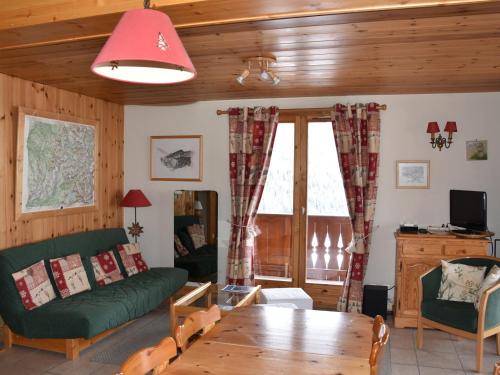 un salon avec un canapé vert et une table dans l'établissement Appartement spacieux proche télécabine avec terrasse et WiFi - FR-1-464-51, à Champagny-en-Vanoise
