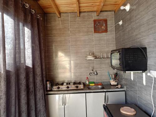 a small kitchen with a stove and a sink at Studio with a spacious garden in Al-Assla in Dahab