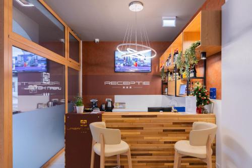 un restaurante con un bar con sillas blancas en Hotel Urban, en Baia Mare