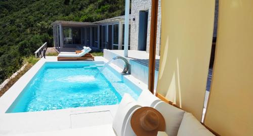 a swimming pool on the side of a house at Urania Luxury Villa Rhea in Póndi