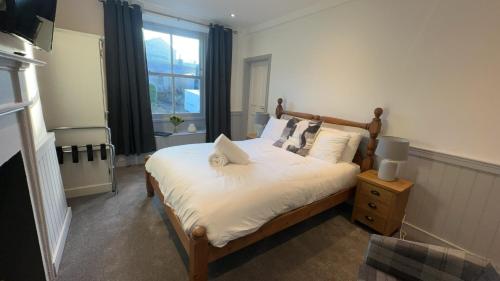 1 dormitorio con 1 cama con sábanas blancas y ventana en The White Bull, en Gisburn
