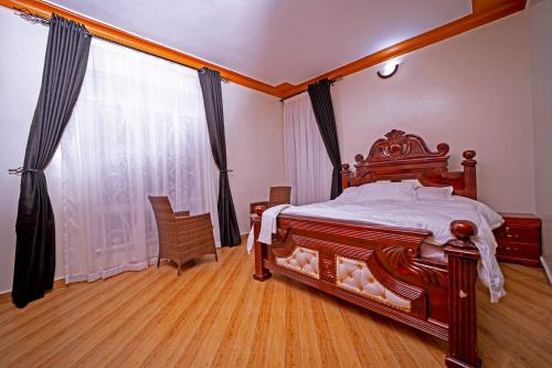 a bedroom with a large wooden bed and a window at Kibibi Lake view furnished suites in Wakiso