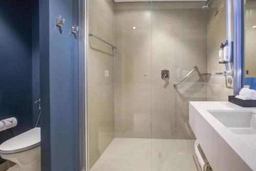 a bathroom with a shower and a toilet and a sink at Hilton Garden Inn São José do Rio Preto in Sao Jose do Rio Preto