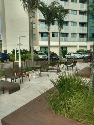 a patio with tables and chairs in front of a building at Samba Rio - Farmasi Arena - Rio Centro - Parque Olimpico - Projac - Barra in Rio de Janeiro