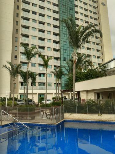a pool with palm trees in front of a building at Samba Rio - Farmasi Arena - Rio Centro - Parque Olimpico - Projac - Barra in Rio de Janeiro