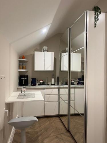 a kitchen with white cabinets and a sink at Attic Room in Citywest in Dublin