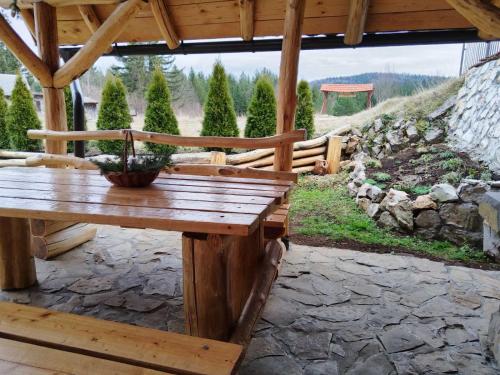 a wooden bench sitting on a stone patio at Vila Šapat šume in Ljuboš