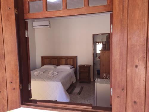 ein Schlafzimmer mit einem Bett und einem großen Spiegel in der Unterkunft Chalé da Selma I (Isaías) in Alto Paraíso de Goiás