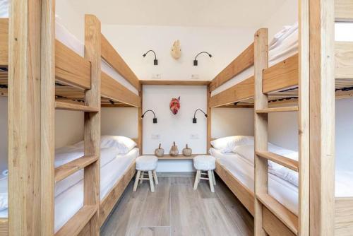 Pokój z 2 łóżkami piętrowymi i biurkiem w obiekcie Wasserfall Lodge Krimml w mieście Krimml