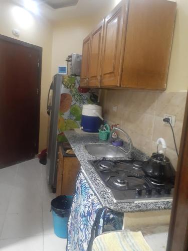 a small kitchen with a stove and a sink at Kazpilkna Beach Neighborhoods in Hurghada