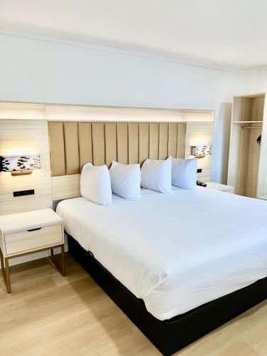 舊金山的住宿－弗朗西斯科灣旅館，卧室配有一张带白色床单和枕头的大床。