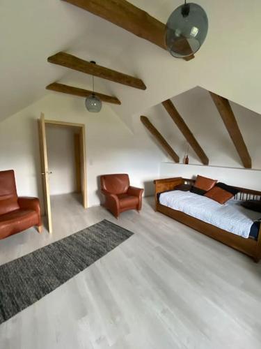 1 dormitorio con 1 cama y 1 silla en el ático en Entzückendes Häuschen, neu ren., en Groß-Siegharts