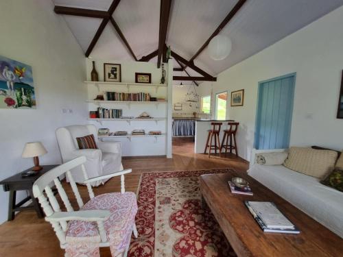 un soggiorno con divano e tavolo di Sitio Carpir - conforto, charme e natureza a 2h de SP a Paraibuna