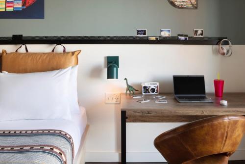 a bedroom with a bed and a desk with a laptop at Moxy Halifax Downtown in Halifax